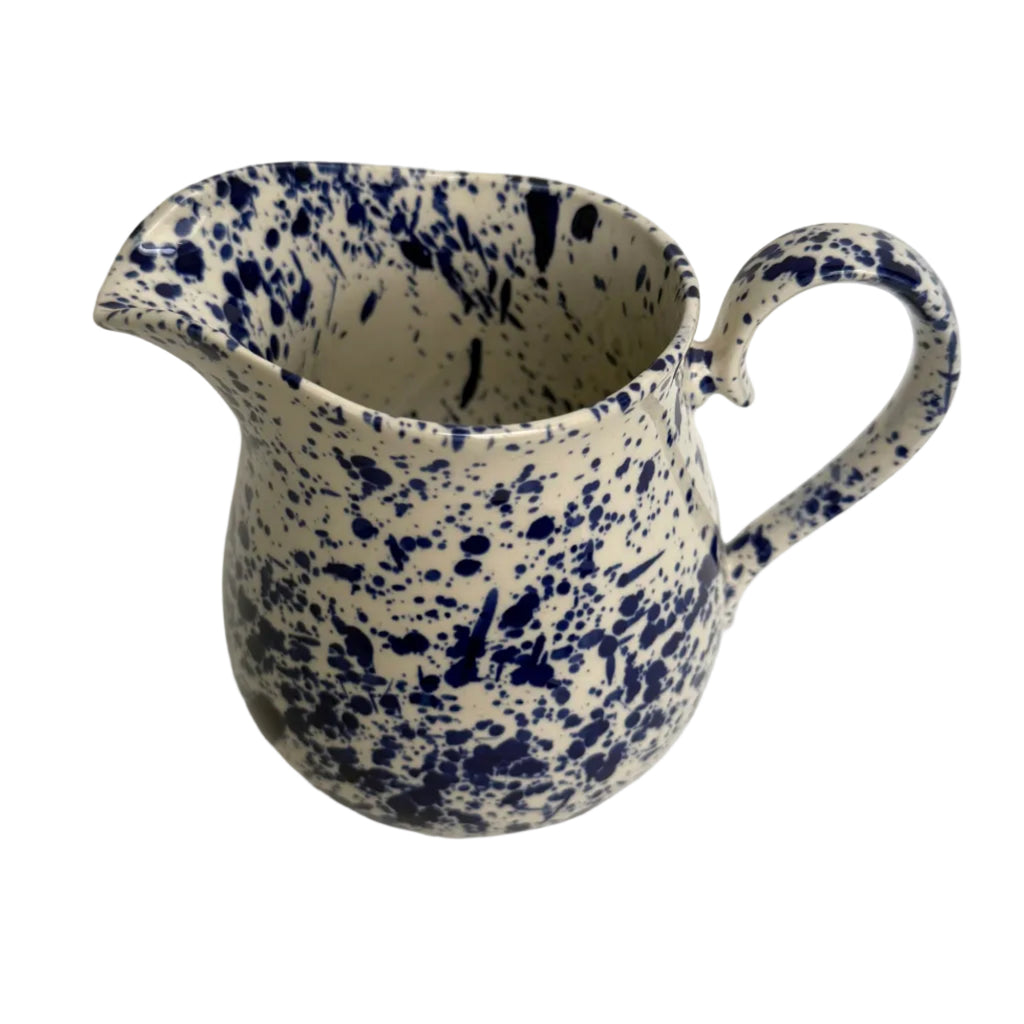 Ceramic pitcher with blue speckled pattern on a white background