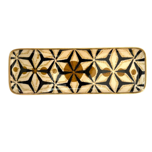 Rectangular ceramic dish with black star pattern on a white background