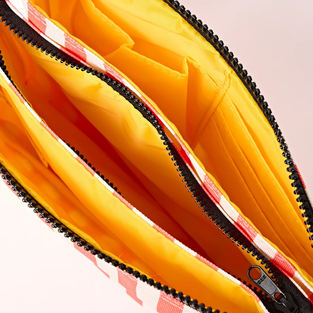 Roka Close-up of a yellow bag with a black zipper and red interior lining.