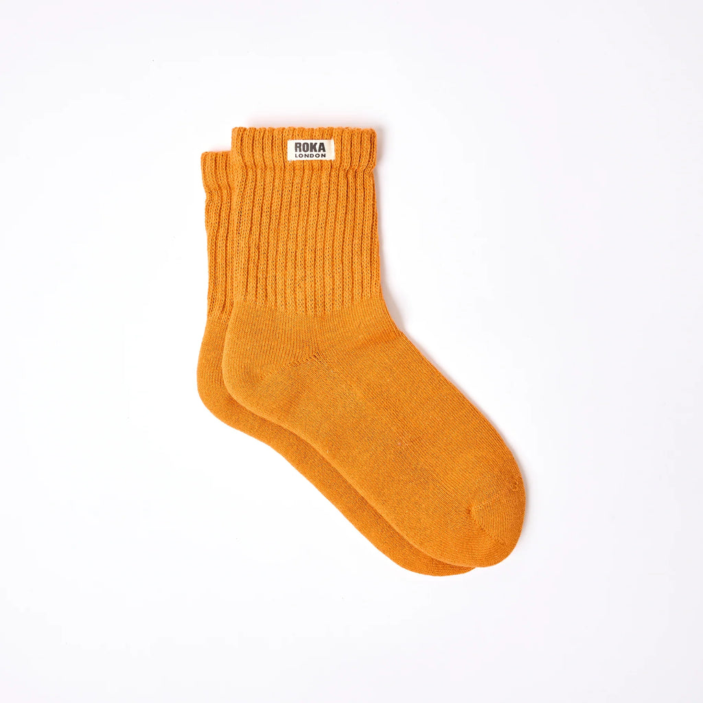 Roka Orange sock with 'ROKA' label on a white background