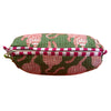 Green and pink patterned pouch with a striped handle on an orange background