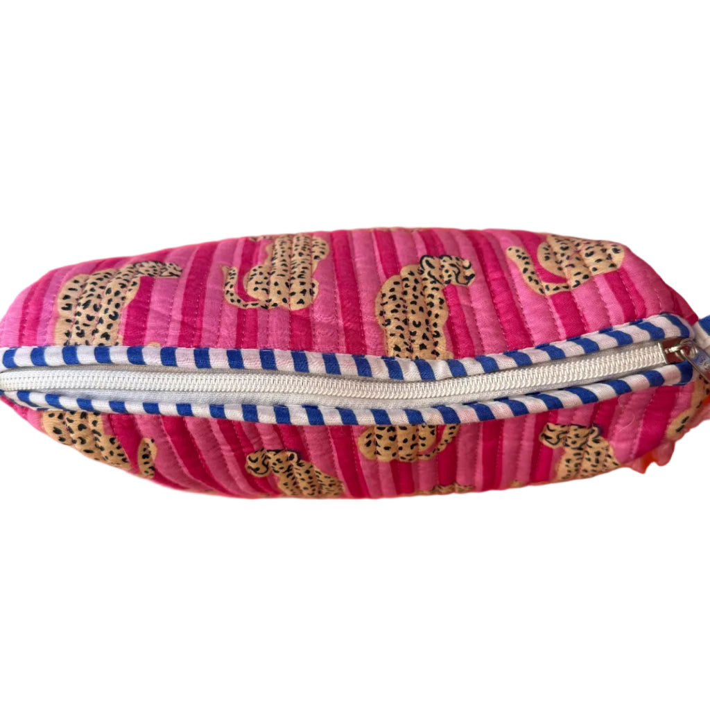 Pink pouch with leopard print and blue zipper on an orange background